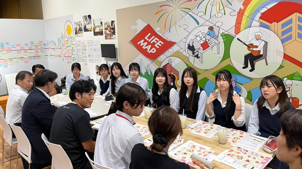 ライフマップの壁画の前で意見を交わす生徒と担当者